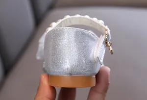 Gros plan sur les chaussures de princesse argentées à paillettes pour filles avec bride