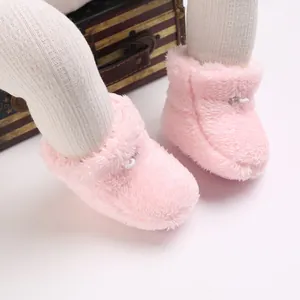 Gros plan de chaussons d'hiver en peluche rose doux pour le confort du bébé