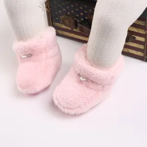 Détail rapproché de bottes d'hiver en peluche rose pour bébé avec leggings blancs