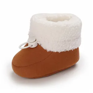 Gros plan de bottines d'hiver pour bébé avec polaire sherpa blanche et cordon réglable