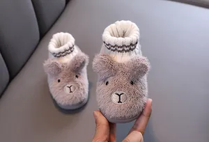 Nahaufnahme von Plüsch-Hausschuhen für Kinder mit warmem Strickkragen für den Winter.