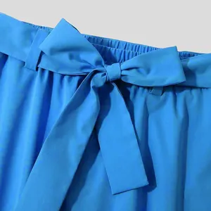 Close-up of matching blue fabric belt tied in a bow on men's casual cropped pants