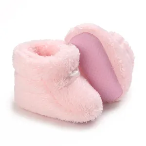 Vue détaillée de bottines bébé en peluche rose avec semelle antidérapante à picots.