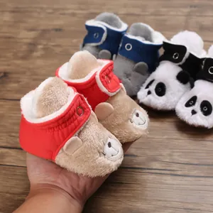 Primer plano de botas de nieve de felpa para bebé con diseño de oso y forro suave.