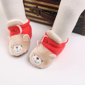 Primer plano de botas de invierno para bebé con oso de peluche y suave tela de color rojo
