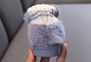 Detailansicht der Rückseite grauer Kinder-Plüschhausschuhe mit warmem Strickkragen.