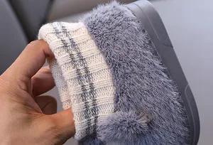 Nahaufnahme von Kinder-Hausschuhen mit weichem Strickbund und dickem Kunstfell-Material.