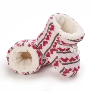 Dettaglio di caldi stivaletti invernali rosa per neonati con cuori e fodera in pile.