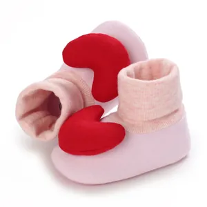 Detailansicht von rosa Baby-Laufsocken mit großem rotem weichem Plüschherz-Dekor