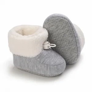 Vue détaillée de bottes d'hiver bébé grises avec doublure polaire blanche et semelle antidérapante.