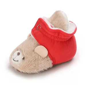 Detalle de botas de invierno suaves para bebé con diseño de cara de oso de peluche
