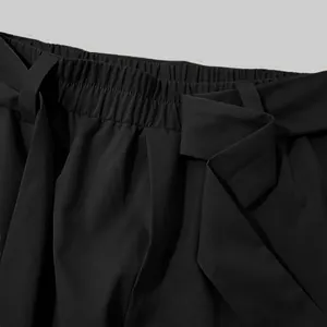 Detail of black men's cropped casual pants with elastic waist and fabric belt.