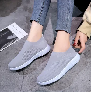 Vue détaillée des baskets en maille grise respirante pour femmes portées par le modèle