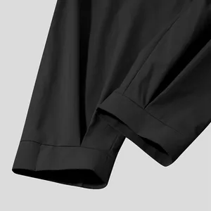 Detailed close-up of the hem and fabric texture of black men's casual cropped pants.
