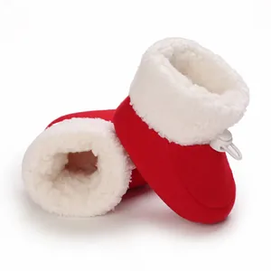 Vue détaillée de chaussons bébé chauds en peluche rouge et blanc avec cordon ajustable.
