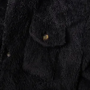 Detailed close-up of premium black fuzzy fleece jacket material with pocket and button