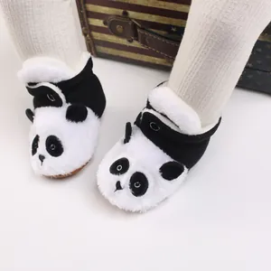 Primer plano de adorables botas de nieve de peluche de panda para el invierno de bebé