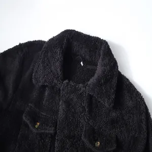 Detail shot of black fuzzy plush jacket showing textured collar and buttoned chest pockets