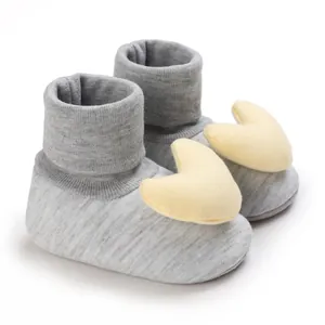 Nahaufnahme von Baby-Laufsocken mit gelber Herz-Plüschdekoration für Kleinkinder