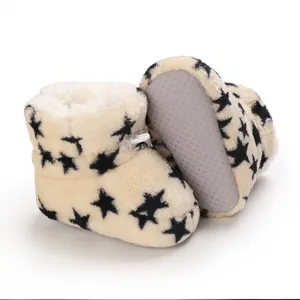 Detalle de botas de invierno de felpa para bebé con patrón de estrellas y suela suave