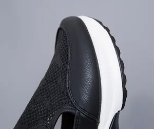 Primo piano del mesh traspirante e della spessa suola bianca delle scarpe nere