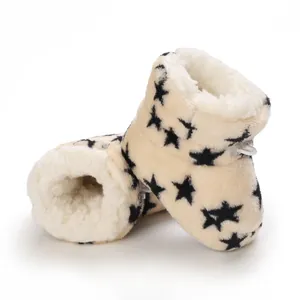 Detalle de las botas de peluche para bebé con diseño de estrellas y forro cálido blanco