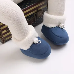 Détail de bottines bleues pour bébé doublées de polaire avec serrage réglable au pied.