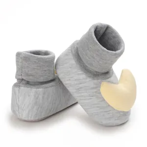 Detailansicht der weichen Strickstruktur und des gelben Mondaufnähers bei Babysocken