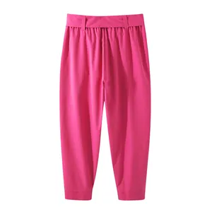 Detail view of vibrant pink men's loose cropped trousers with stylish waist belt
