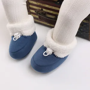 Vue détaillée de chaussons bleus pour bébé avec doublure en fausse fourrure et cordon réglable