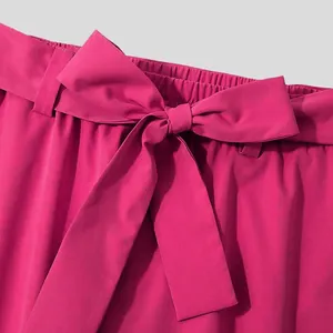 Close-up of fuchsia casual pants featuring an elastic waist and a matching tie belt