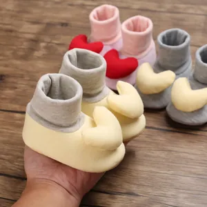 Nahaufnahme von weichen Baumwoll-Babylaufsocken mit niedlichem Plüschherz-Dekorationsdetail