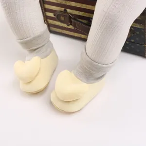 Nahaufnahme von gelben Baby-Laufsocken mit weicher Herzdekoration und Rippbündchen
