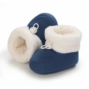 Détail de chaussons d'hiver pour bébé bleu marine doublés polaire avec cordon blanc