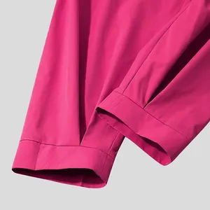 Close-up detail of the hem on fuchsia men's cropped pants showing high-quality stitching