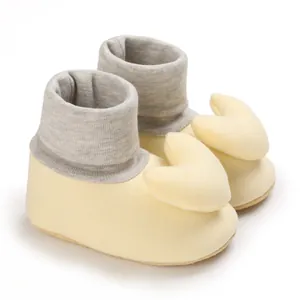 Detailaufnahme von gelben Baby-Laufsocken mit großem, weichem Herz-Ornament