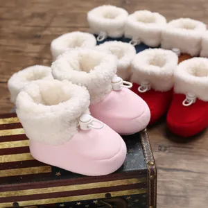Détail des bottes d'hiver roses pour bébé avec doublure en fausse fourrure et lacet.