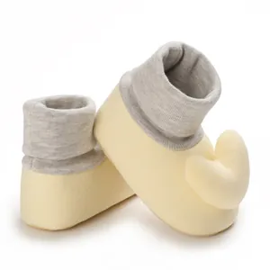 Detailansicht gelber Baby-Laufsocken mit grauen Rippbündchen und Herz-Applikation