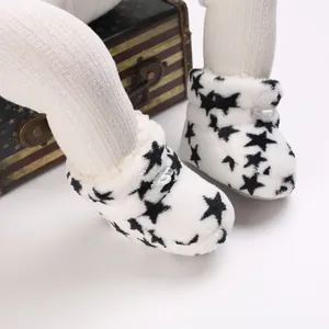 Primer plano de botas de invierno para bebé con estrellas negras en felpa suave