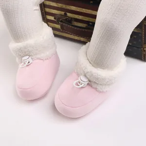 Gros plan de chaussures d'hiver roses doublées de polaire pour bébé avec arrêt de cordon
