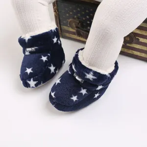 Primer plano de botas de invierno para bebé azul marino con estrellas blancas y forro suave