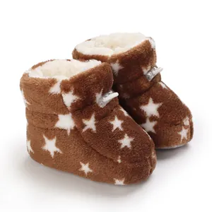 Vista detallada de botas de bebé de felpa marrón con estrellas blancas y forro polar suave