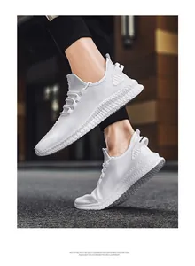 Detail view of breathable white fly-knit men's sneakers with lightweight EVA sole.