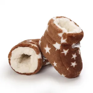 Vista detallada de la textura suave de botas de peluche marrones con estrellas blancas