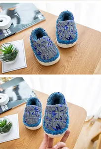 Detalle de botas de nieve impermeables para niños con forro de felpa azul y letras.