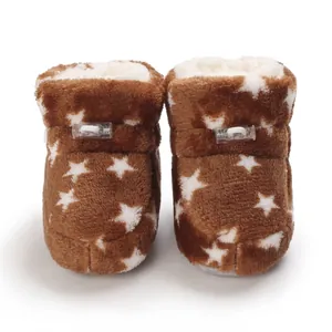 Vista detallada de botas de felpa para bebé en marrón con estrellas blancas y forro.