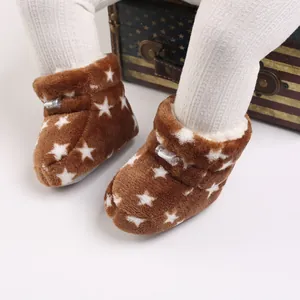 Detalle de botas de invierno de felpa para bebé con patrón de estrellas y suelas blandas