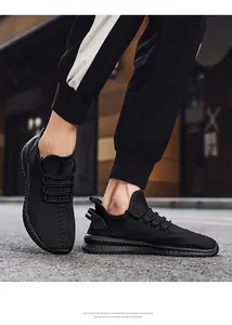 Detailed view of men's black breathable fly-knit sneakers featuring lightweight EVA foam sole