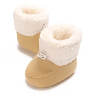 Gros plan de chaussures d'hiver chaudes pour bébé avec polaire blanche et tissu beige