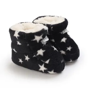 Primer plano de botas de invierno de felpa negra para bebé con diseño de estrellas.